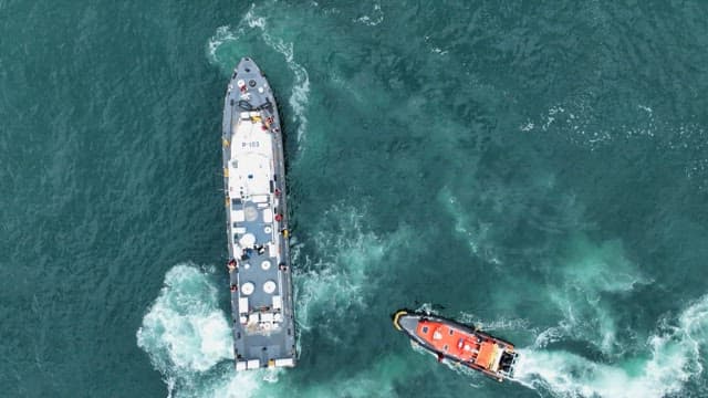 Coast Guard Boat heading towards a large ship at sea