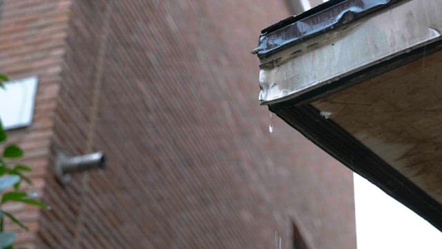 Drizzle on a metal roof of a building during a rainy day