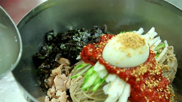 Adding cold broth to spicy buckwheat noodles