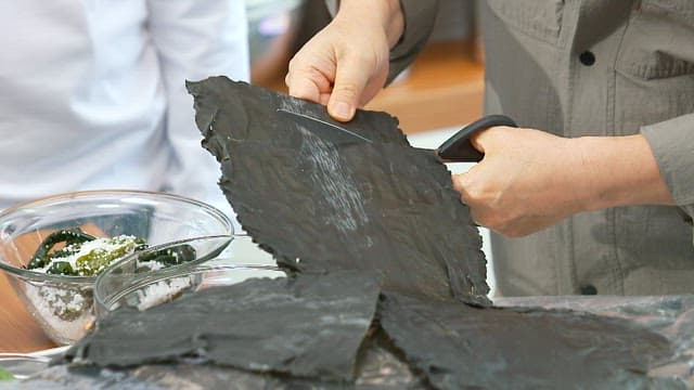 Preparing dried kelp with scissors in the kitchen