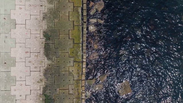 Coastal walkway with adjacent calm waters on a sunny day