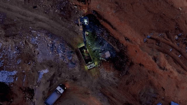 Construction site with trucks and excavator