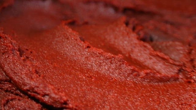 Red pepper paste being scooped into a bowl