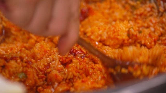 Mixing spicy julienne Korean radish salad bibimbap with a spoon