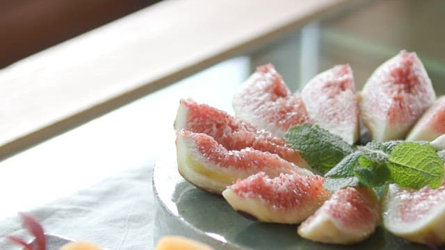 Figs and persimmon slices neatly arranged on a plate