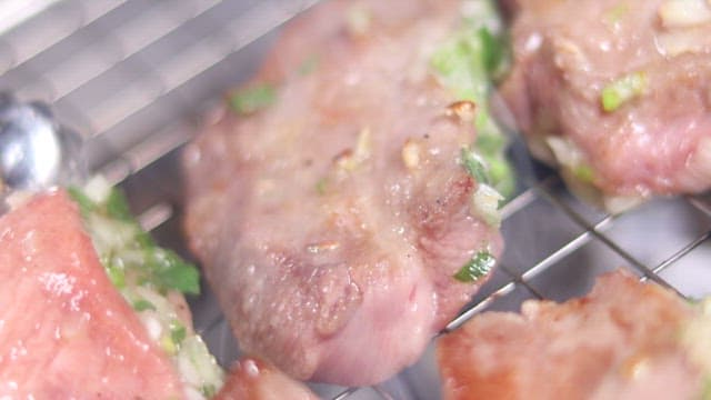 Sizzling Meat on a Smoky Grill